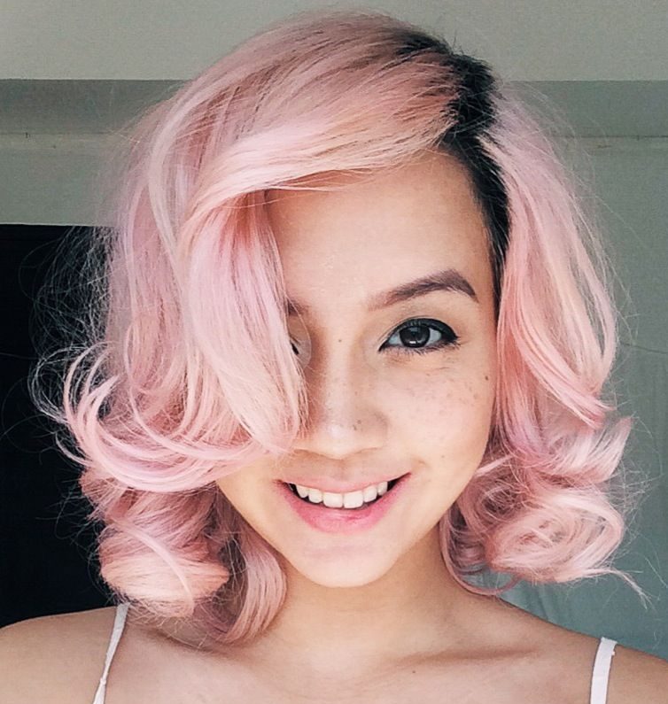 Short pastel pink hair with dark roots